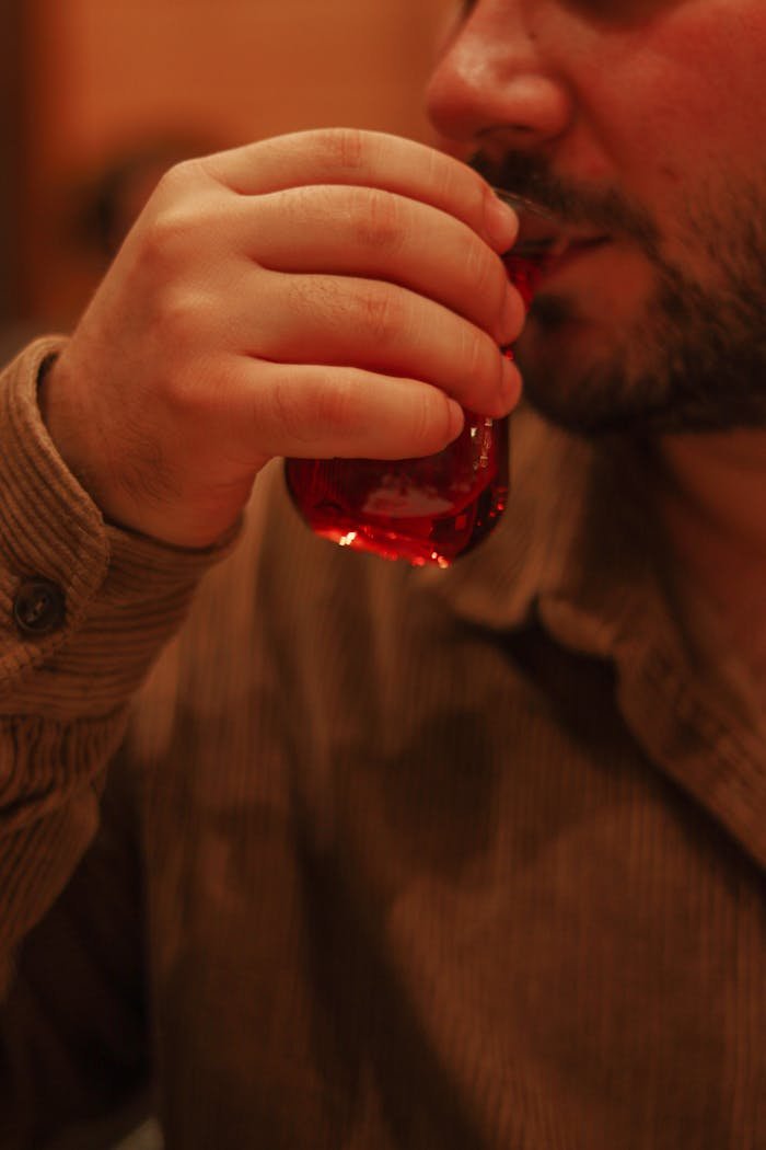 Close-up of a man enjoying Turkish tea from a traditional glass cup in Izmir, Turkey.